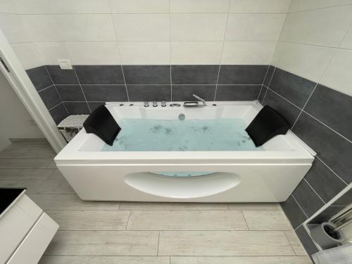 a bath tub in a tiled bathroom with a tub at Charme Lake Loft in Ispra