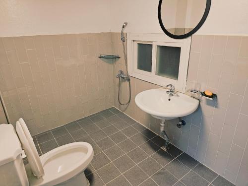 a bathroom with a toilet and a sink and a mirror at Cozy Butter Stay Jeonju in Jeonju