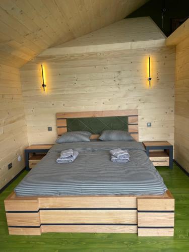 Family cottage في يابلونيتسيا: سرير في غرفة خشبية عليها منشفتين