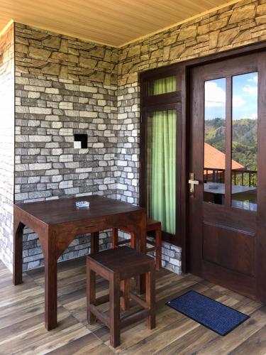 a wooden table and stool in front of a brick wall at Barn Hills in Ella