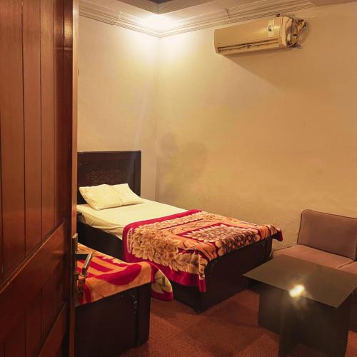 a small room with a bed and a chair at Moon Hotel in Dargai