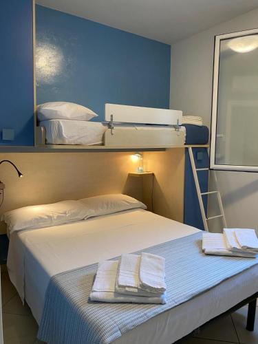 a bedroom with two bunk beds with towels on a bed at Villaaquamarina in Torre dell'Orso