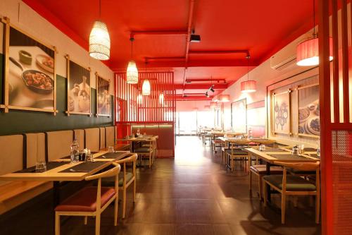 a dining room with tables and chairs and red ceilings at FabExpress Santhi Inn - 500 meters from Promenade Beach in Puducherry