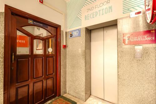 a brown door in the side of a building at FabExpress Santhi Inn - 500 meters from Promenade Beach in Puducherry