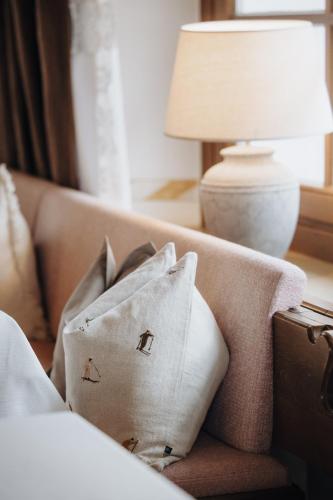 a couch with pillows and a lamp on a table at Hotel Krone Großarl in Grossarl