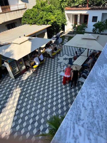 an overhead view of a patio with people sitting at tables and umbrellas at Vila Cano Boutique in Durrës