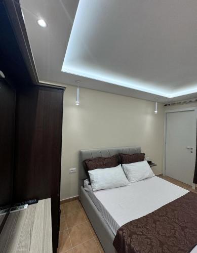 a bedroom with a large bed with white sheets at Vila Cano Boutique in Durrës