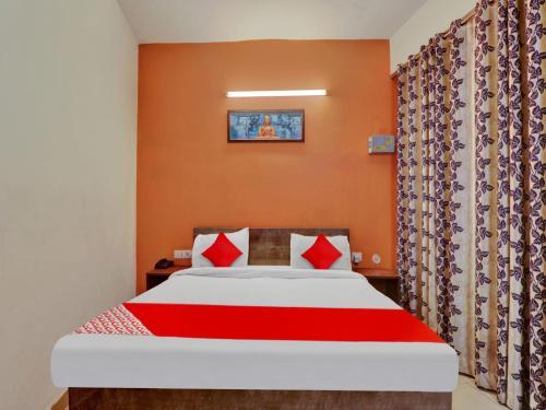 a bedroom with a bed with red pillows at Hotel O SMS in Lucknow