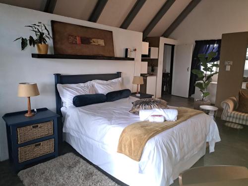 una camera da letto con un letto grande con lenzuola bianche di Casa Mana Air B&B a Pretoria