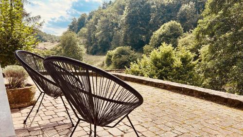 Deux chaises sont installées sur une terrasse avec vue sur les arbres. dans l'établissement Wohnung im Landhaus - mit Terasse & Bachlauf, à Trösel