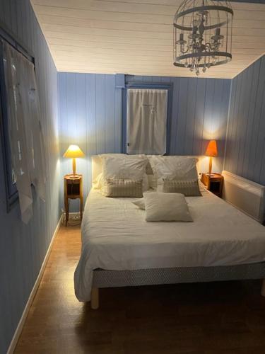 a bedroom with a large bed with a blue wall at Le Gîte Saint Girons in Saint-Girons-dʼAiguevives