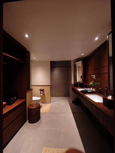 a large bathroom with a sink and a toilet at Chann Bangkok Noi in Bangkok