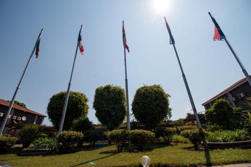 a group of flags on poles in a park at Royal Solwezi Hotel in Solwezi