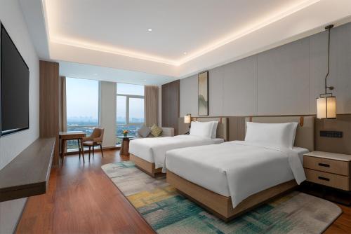Una habitación de hotel con dos camas y un televisor de pantalla plana. en Holiday Inn Xingtai Quancheng by IHG, en Xingtai