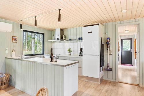 a kitchen with white cabinets and a white refrigerator at LK2096-Lokken-Raevevej-4 in Løkken