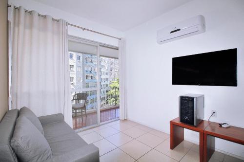 a living room with a couch and a flat screen tv at Conforto! Localização Imbatível em Copacabana U054 in Rio de Janeiro