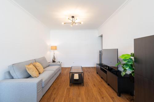 ein Wohnzimmer mit Sofa und Fernseher in der Unterkunft Carcavelos Blue Sea II in Carcavelos