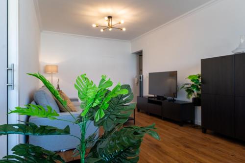 ein Wohnzimmer mit einem blauen Sofa und einem Fernseher in der Unterkunft Carcavelos Blue Sea II in Carcavelos