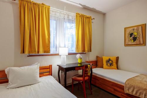 a bedroom with two beds and a desk and a window at Harry nie z tej bajki & Bałtycka44 Apartments in Olsztyn
