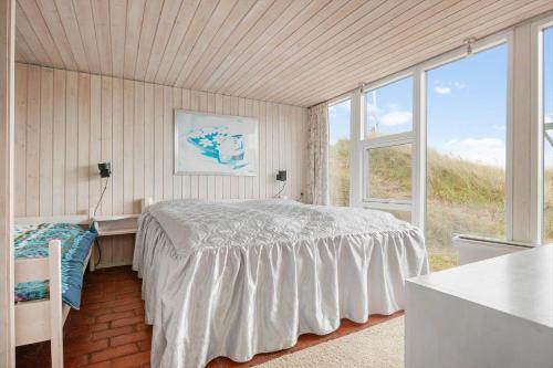 a bedroom with a bed and a large window at LK2118-Lokken-Jomfrubakkerne-15 in Løkken