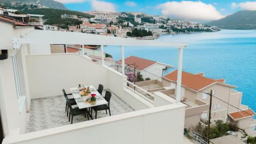 a balcony with a table and chairs overlooking the water at Villa Green Mak in Neum