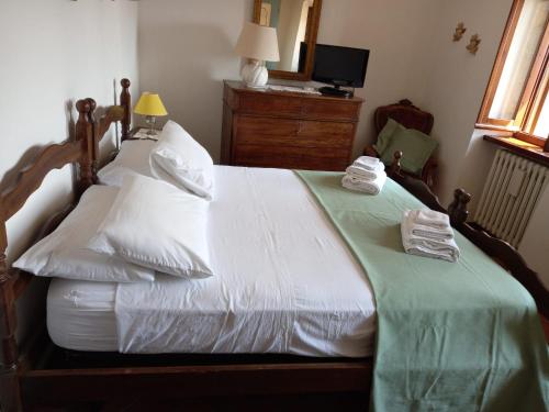 a bedroom with a bed with white sheets and pillows at La casa di MonAmì in Spello
