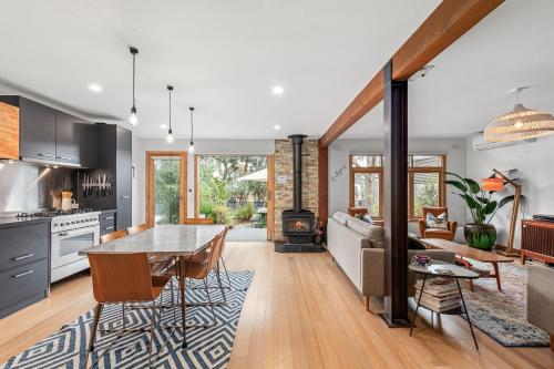 a kitchen and living room with a table and a couch at Cottesloe Beach Shack Barwon Heads in Barwon Heads