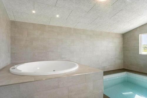 a bathroom with a tub and a swimming pool at LK1886-Lokken-Kallehaven-3 in Løkken