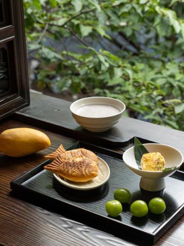 a tray with a plate of food and a plate of fruit at Dali Zhi'an Hotel in Dali Ancient Town