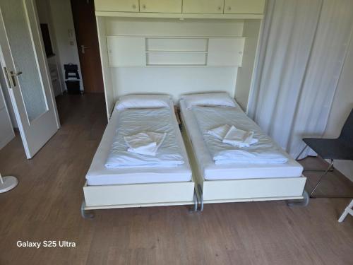 two beds sitting next to each other in a room at PEMATRA Ferienwohnungen Ostseestrasse 2 in Travemünde