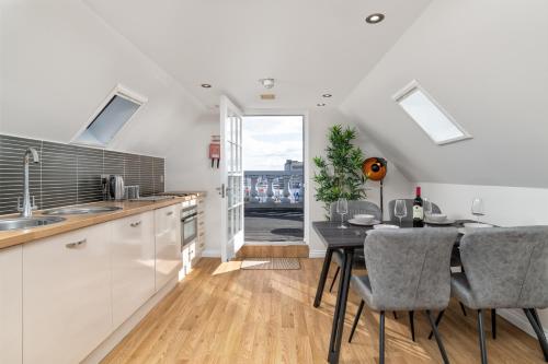 a kitchen with a table and a dining room at Victoria Court Suites - Aberdeen in Aberdeen