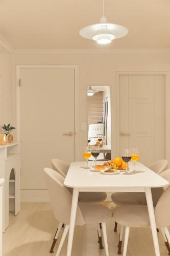a white dining room with a white table and chairs at Nldam Stay Seoul Station Walk 8min Near Namsan Tower, Easy to Hongdae, Myeongdong,DDP in Seoul