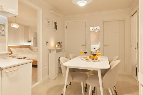 a kitchen and dining room with a white table and chairs at Nldam Stay Seoul Station Walk 8min Near Namsan Tower, Easy to Hongdae, Myeongdong,DDP in Seoul