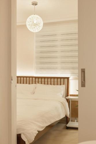 a bedroom with a white bed and a chandelier at Nldam Stay Seoul Station Walk 8min Near Namsan Tower, Easy to Hongdae, Myeongdong,DDP in Seoul