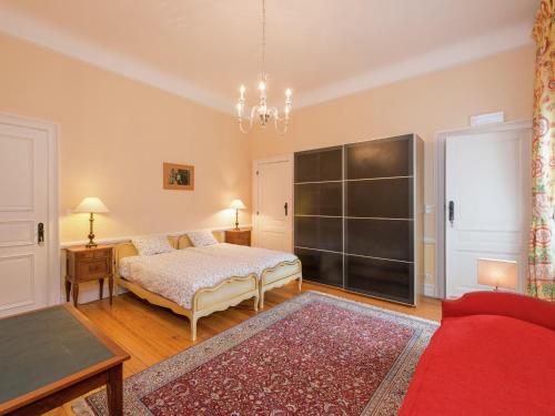 a bedroom with a bed and a table and a couch at Beautiful manor house in a park near Rochefort in Forrières