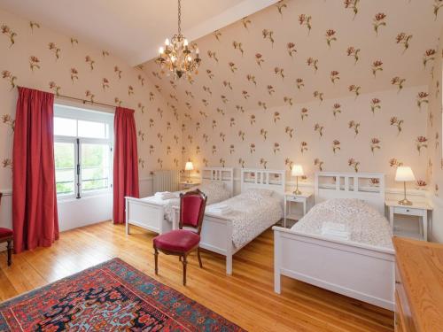 a bedroom with two beds and a desk at Beautiful manor house in a park near Rochefort in Forrières