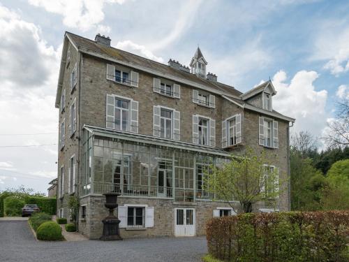 a large brick building with windows on the side of it at Beautiful manor house in a park near Rochefort in Forrières