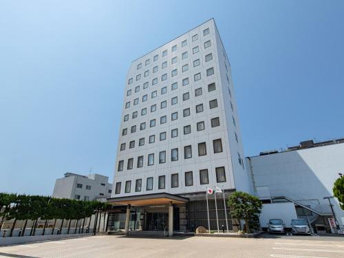 a white building with a lot of windows at Onomichi Kokusai Hotel in Onomichi