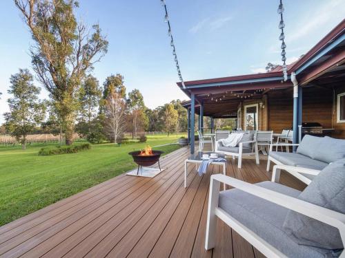 a wooden deck with a fire pit on a house at Burton Farmhouse - Reconnect with Nature & Family in Wilyabrup