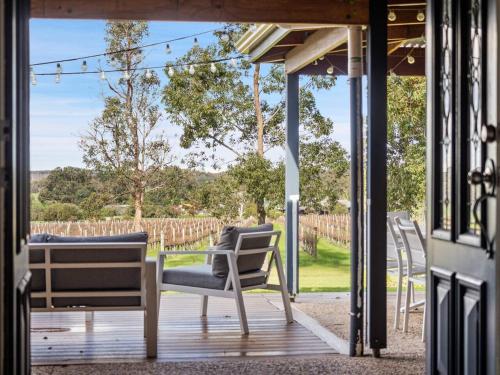 a porch with chairs and a view of a yard at Burton Farmhouse - Reconnect with Nature & Family in Wilyabrup
