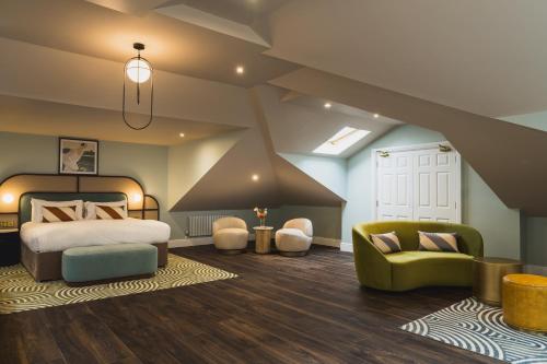 a bedroom with a bed and a couch and a chair at Grange Hotel in Grange Over Sands