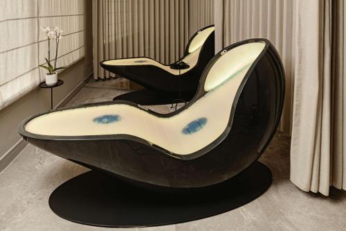 a black and white chair sitting in a room at Radisson Blu Resort & Spa, Malta Golden Sands in Mellieħa