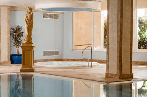 a pool with a statue in the middle of a building at Radisson Blu Resort & Spa, Malta Golden Sands in Mellieħa