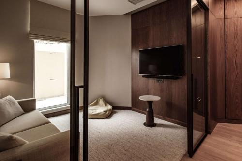 a living room with a couch and a tv at Radisson Blu Resort & Spa, Malta Golden Sands in Mellieħa