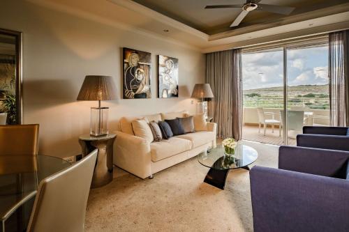 a living room with a couch and a table at Radisson Blu Resort & Spa, Malta Golden Sands in Mellieħa