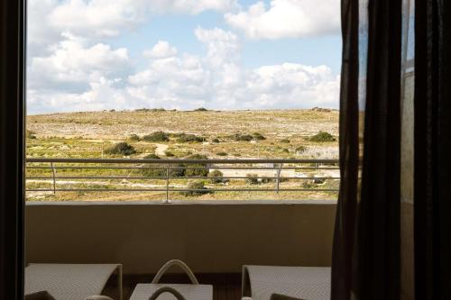 a view of the desert from a window of a room at Radisson Blu Resort & Spa, Malta Golden Sands in Mellieħa