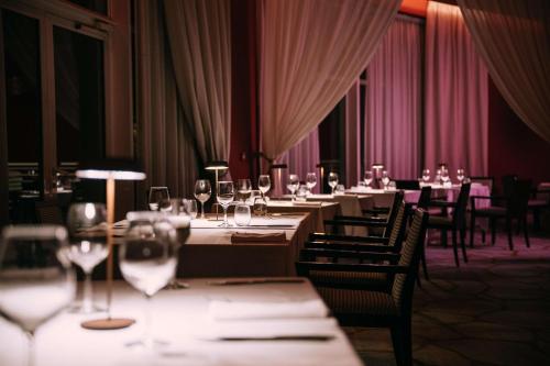 a dining room with many tables and chairs with wine glasses at Radisson Blu Resort & Spa, Malta Golden Sands in Mellieħa