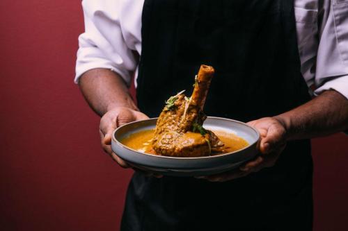 a man holding a plate of food in his hands at Radisson Blu Resort & Spa, Malta Golden Sands in Mellieħa
