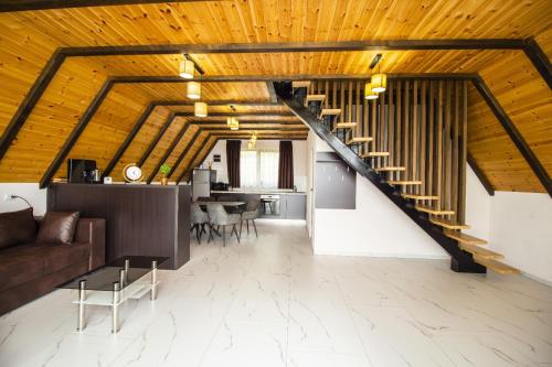 a living room with a wooden ceiling and a staircase at Refugiu de munte in Albac