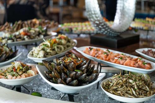 a table with many plates of food on it at Radisson Blu Resort & Spa, Malta Golden Sands in Mellieħa
